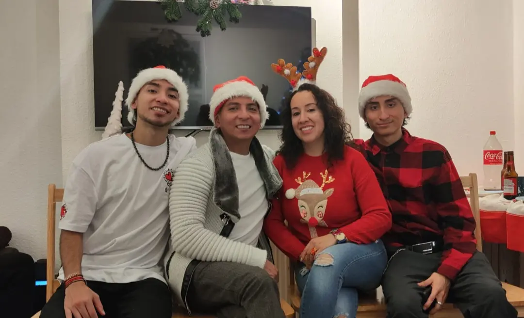 Familia Cuaspa celebrando Navidad en casa con gorros de Papá Noel.
