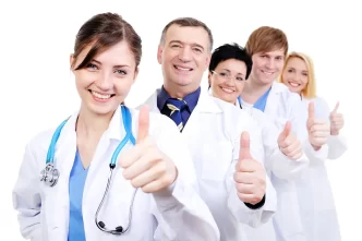 Grupo de médicos sonriendo con pulgar arriba.