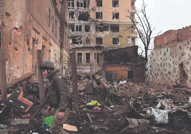 Soldado camina entre edificios destruidos en Ucrania tras la guerra.