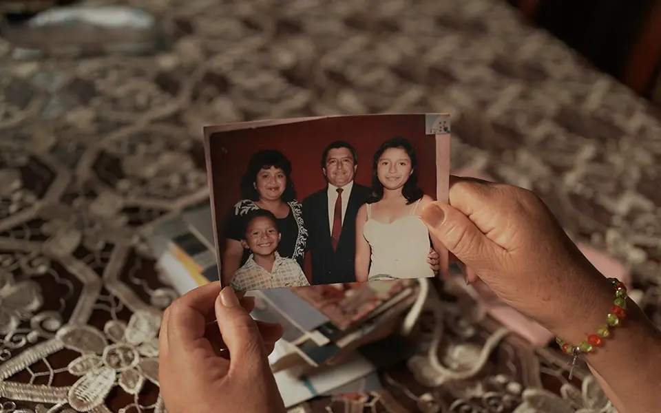 Fotografía de familia sostenida en la mano, escena de película política y familiar.
