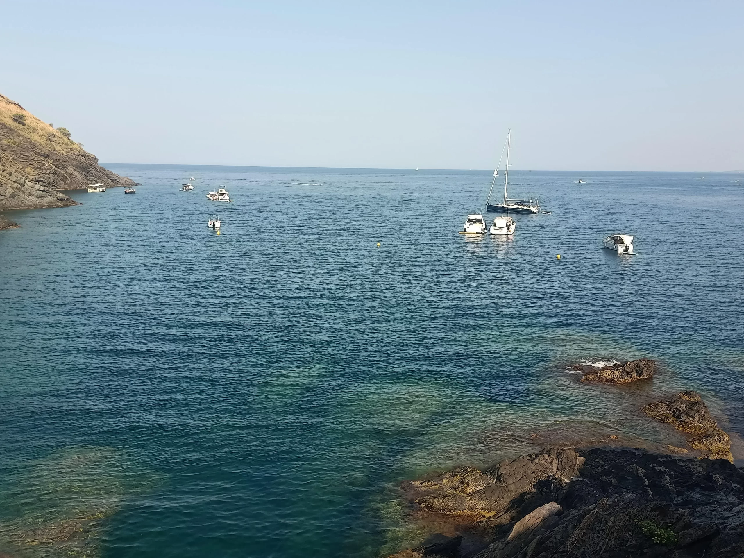 Barcos fondeados en las aguas cristalinas de la bahía de Portbou, Girona