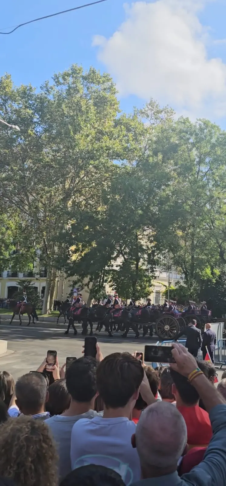 Desfile militar del Día de la Hispanidad en Madrid con público y caballos en el Paseo del Prado.