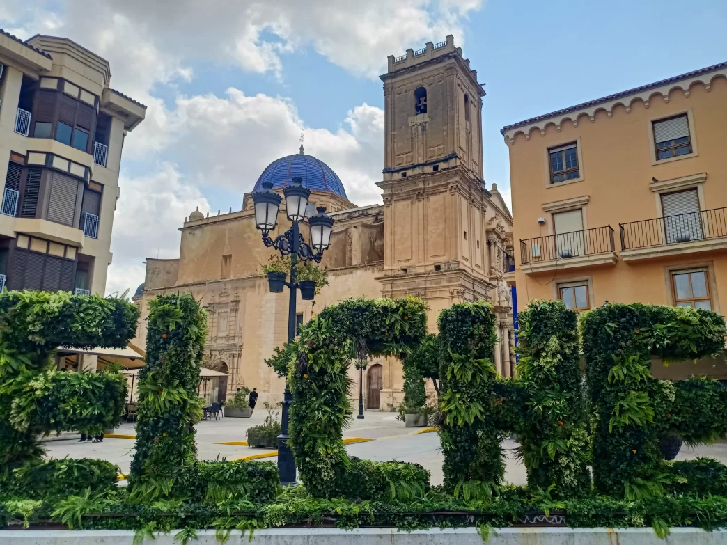 Basílica de Santa María en Elche con letras verdes decorativas que forman la palabra Elche