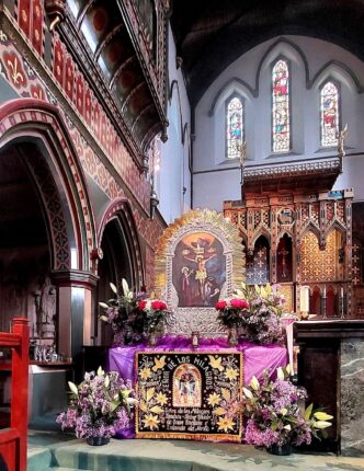 Altar adornado con flores y la imagen del Señor de los Milagros en la iglesia St. Anne de Londres.