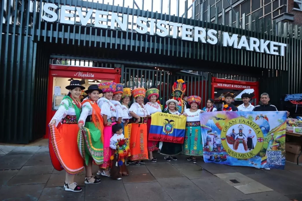 Grupo de bailarines ecuatorianos frente al Seven Sisters Market durante la inauguración del Pueblito Paisa.