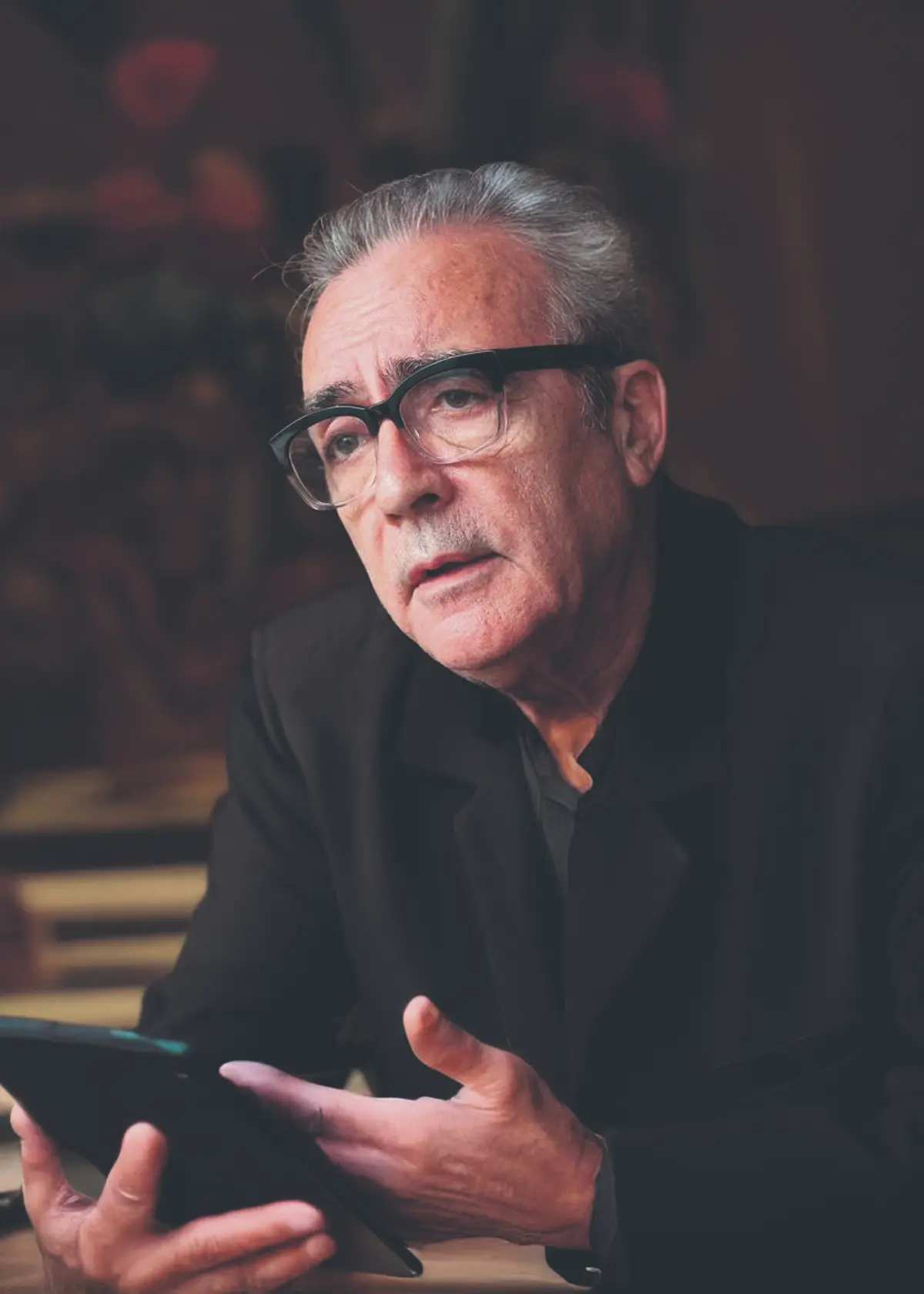 Editoriales en español en UK. Juan José Millás escritor español con tablet