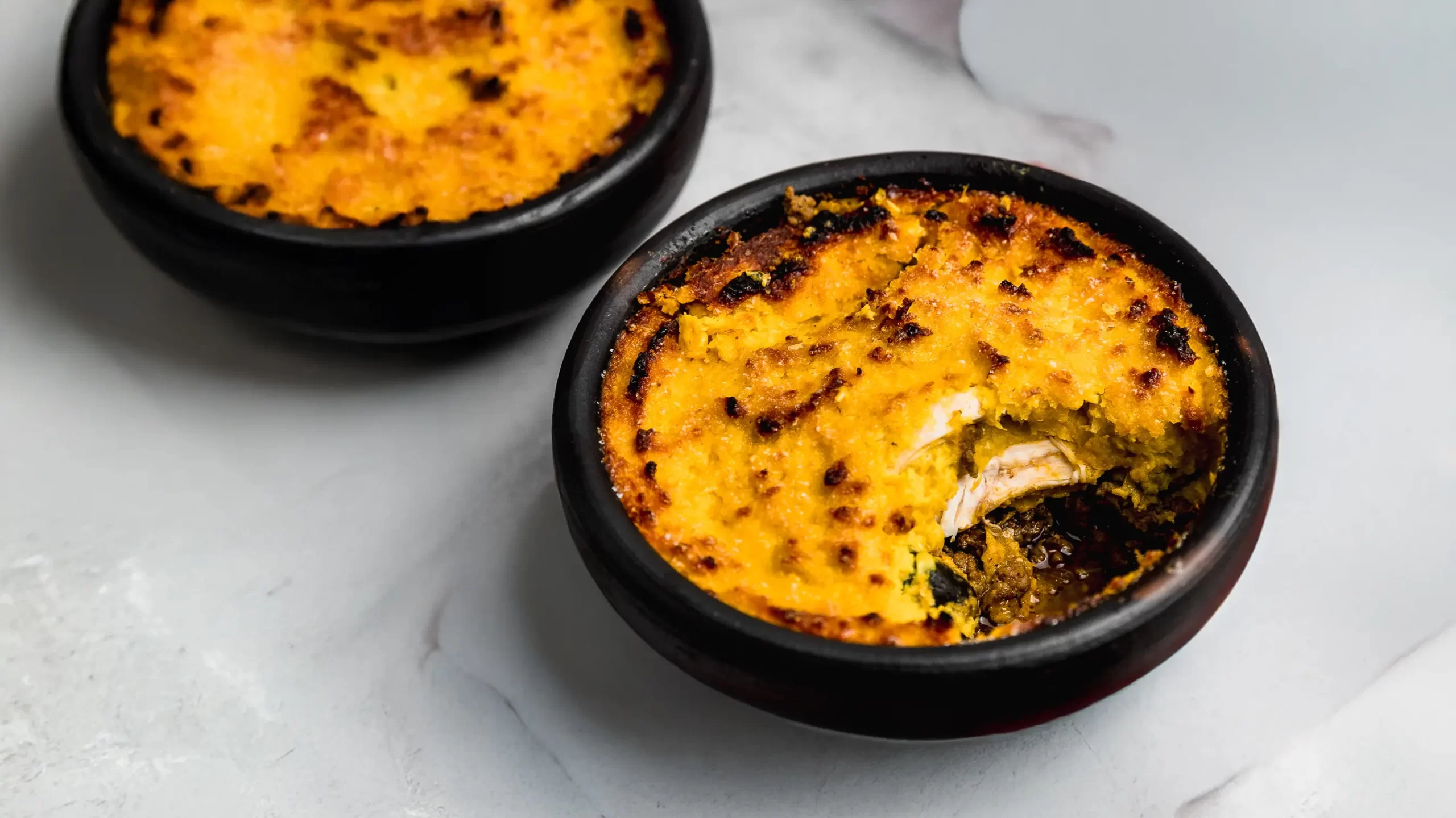 Pastel de choclo chileno servido en plato de greda, receta típica de Chile