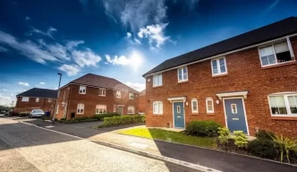 Ley de inquilinos 2025. Calle moderna con casas de ladrillo rojo en Reino Unido, asociada a los cambios en la política de alquiler.