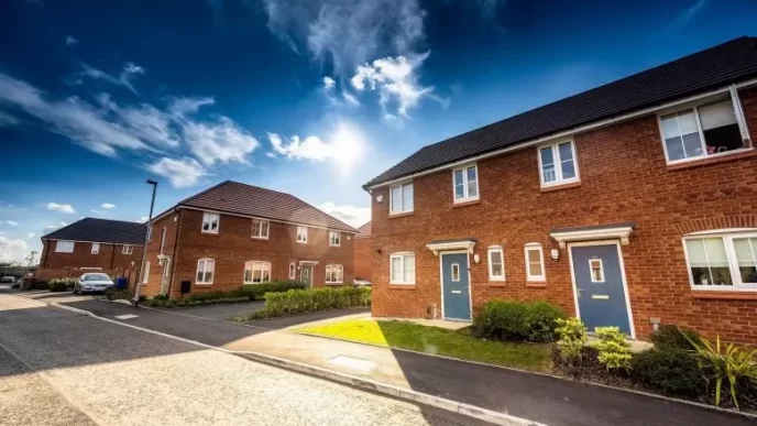 Ley de inquilinos 2025. Calle moderna con casas de ladrillo rojo en Reino Unido, asociada a los cambios en la política de alquiler.