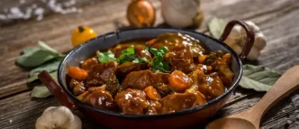 Boeuf Bourguignon cocina francesa servido en cazuela de hierro.