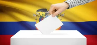 Mano depositando voto frente a la bandera nacional durante el referéndum Ecuador 2025.