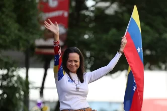 María Corina Machado con bandera venezolana mientras anuncia horas decisivas para Venezuela