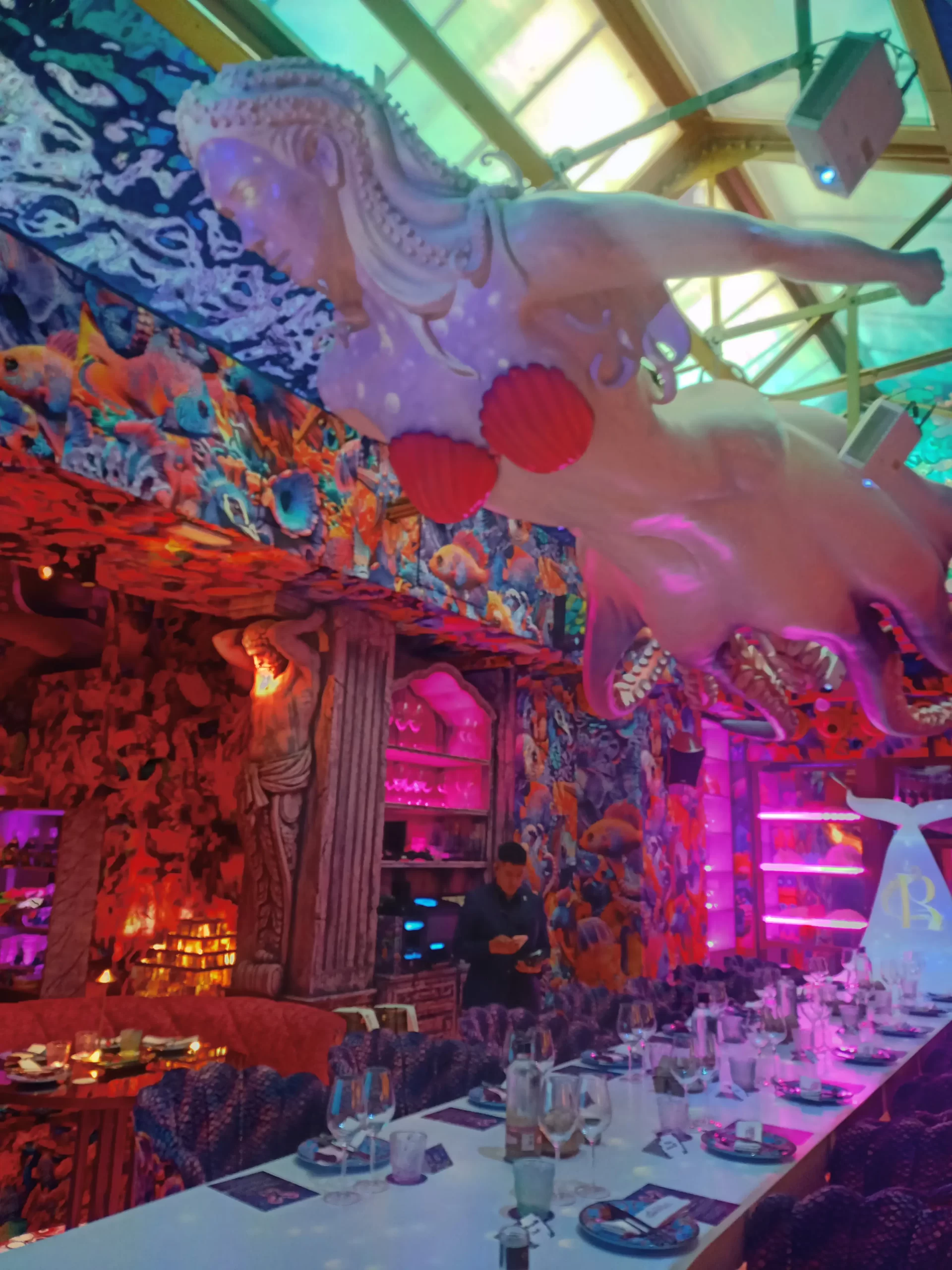 Interior del restaurante Bestial en Madrid con decoración marina y luces neón.