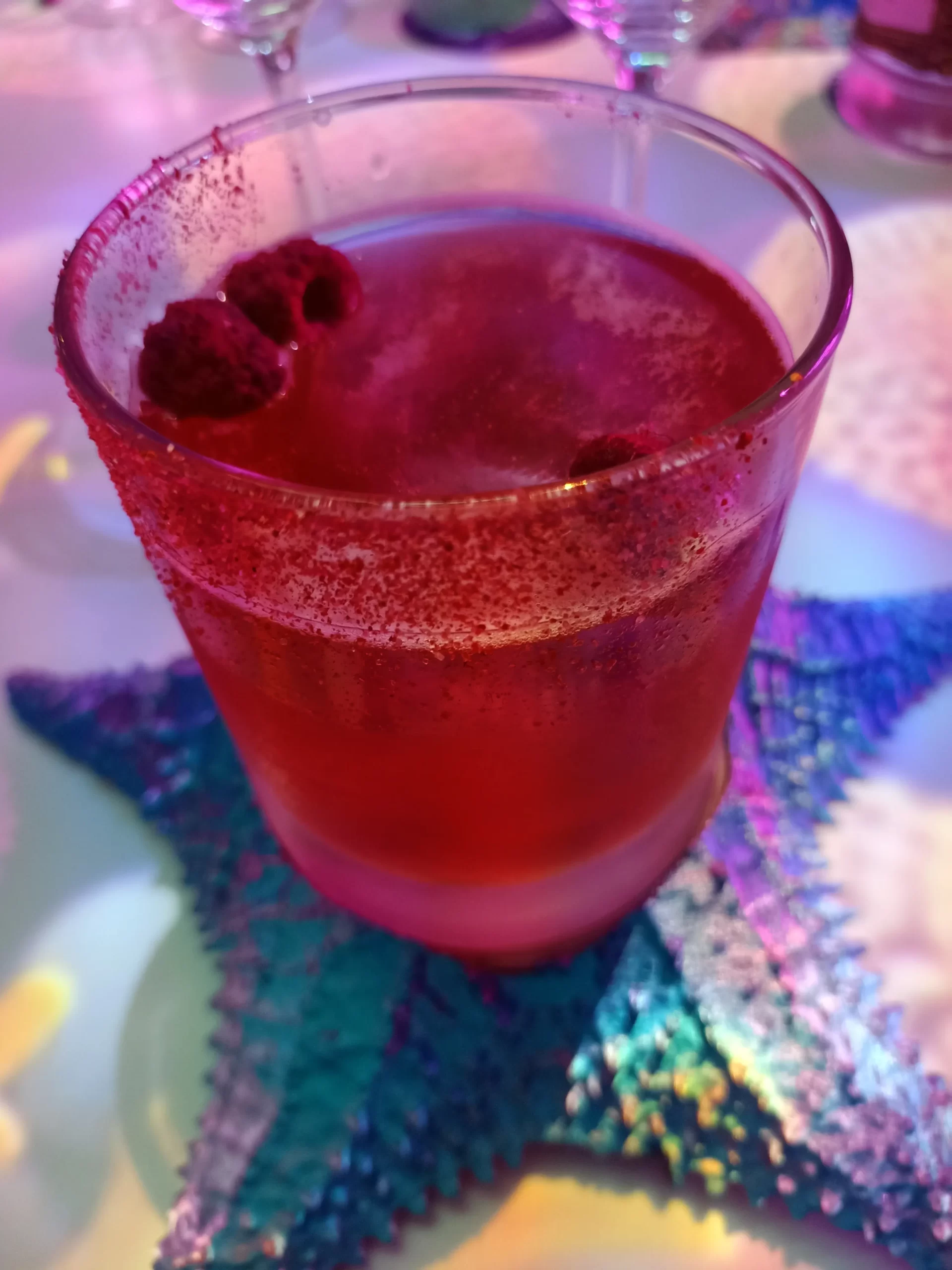 Cóctel de frutos rojos con cava rosado servido sobre decoración marina.