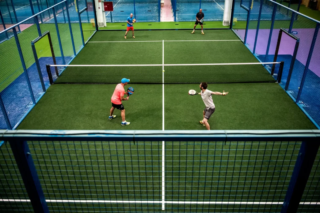 Auge del padel con jugadores en cancha techada.