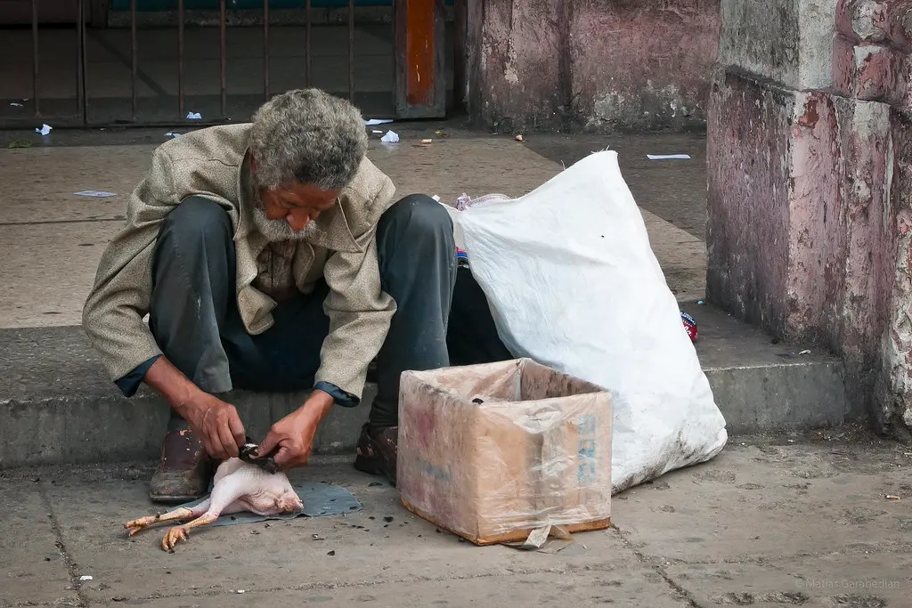 crisis en Cuba con un ciudadano preparando alimentos en la vía pública