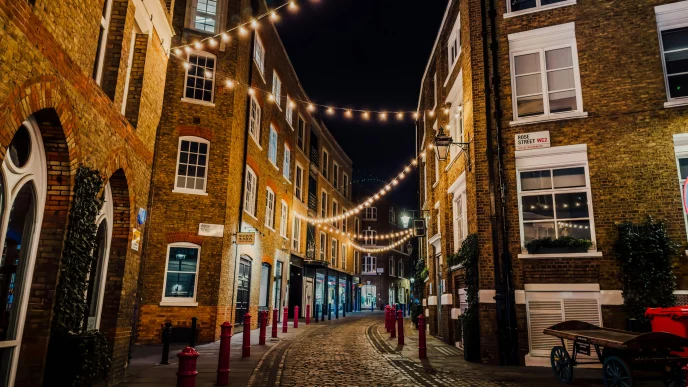 Invierno Reino Unido en una calle empedrada de Londres iluminada por luces nocturnas.