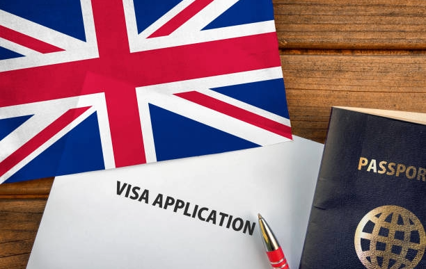 Reforma migratoria Reino Unido con formulario de visa y bandera británica sobre escritorio.