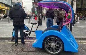 Bicitaxis operando bajo la futura regulación bicitaxis Londres en zona turística.