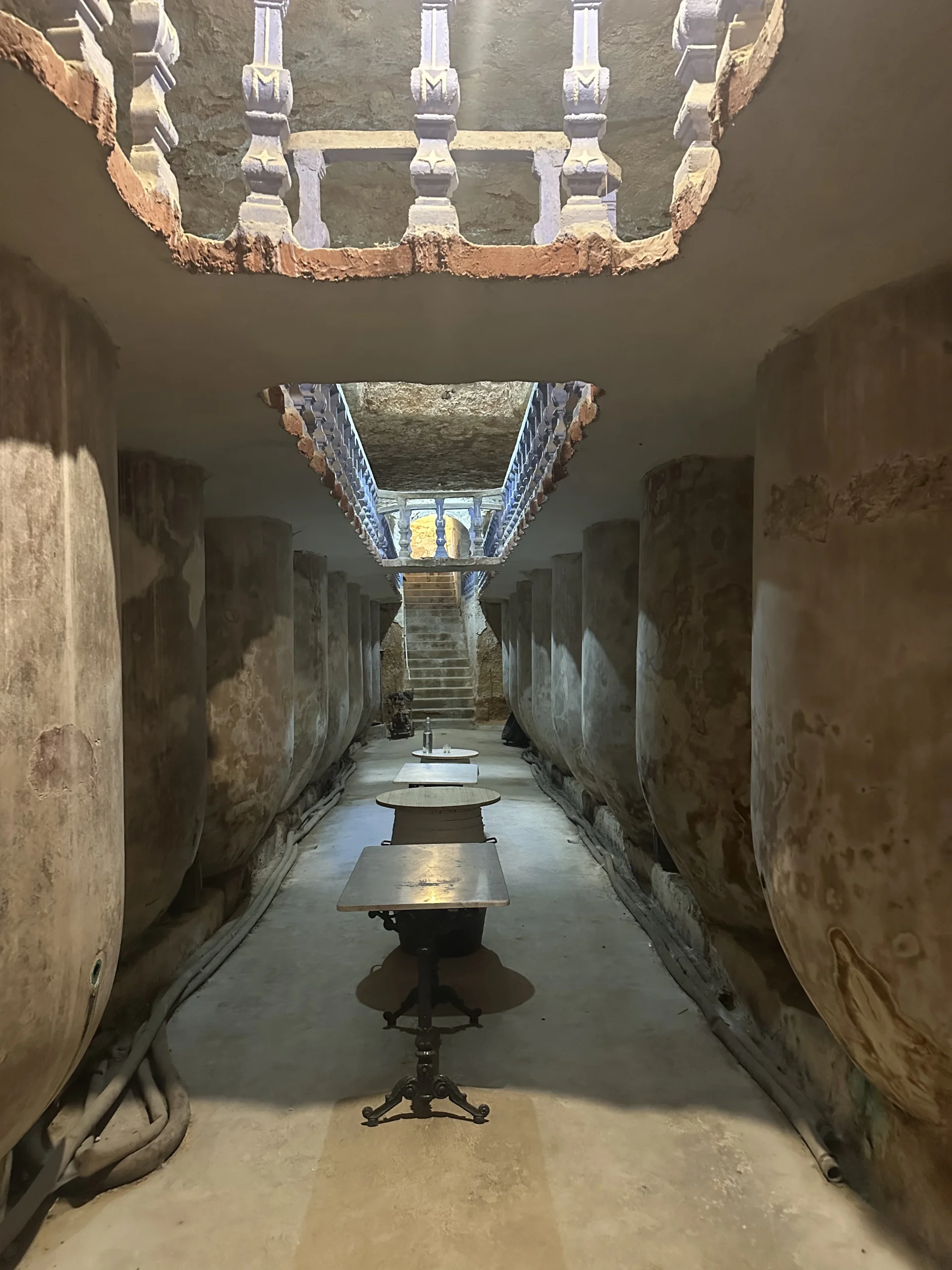 Tomelloso enoturismo en cueva subterránea con grandes tinajas de barro para almacenar vino.