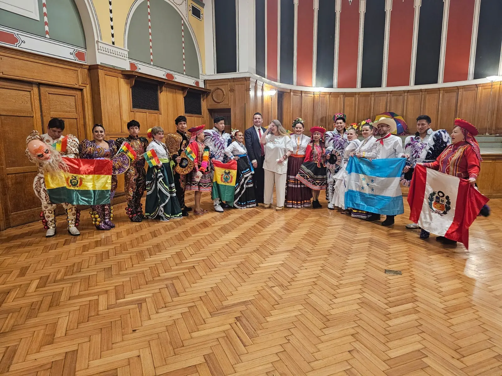 Desfile Año Nuevo Londres con agrupaciones latinas mostrando trajes tradicionales y banderas