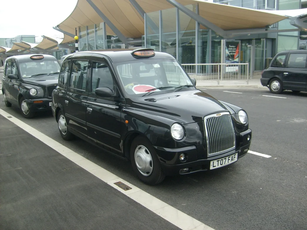 Londres con los taxis más caros muestra taxis negros estacionados frente a una terminal moderna