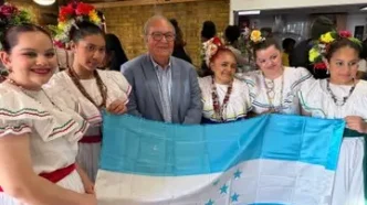 Garífunas en Londres durante la celebración de los 229 años de su llegada a Honduras junto a la bandera hondureña.