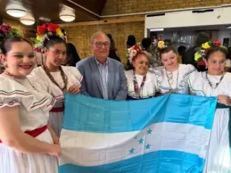 Garífunas en Londres durante la celebración de los 229 años de su llegada a Honduras junto a la bandera hondureña.