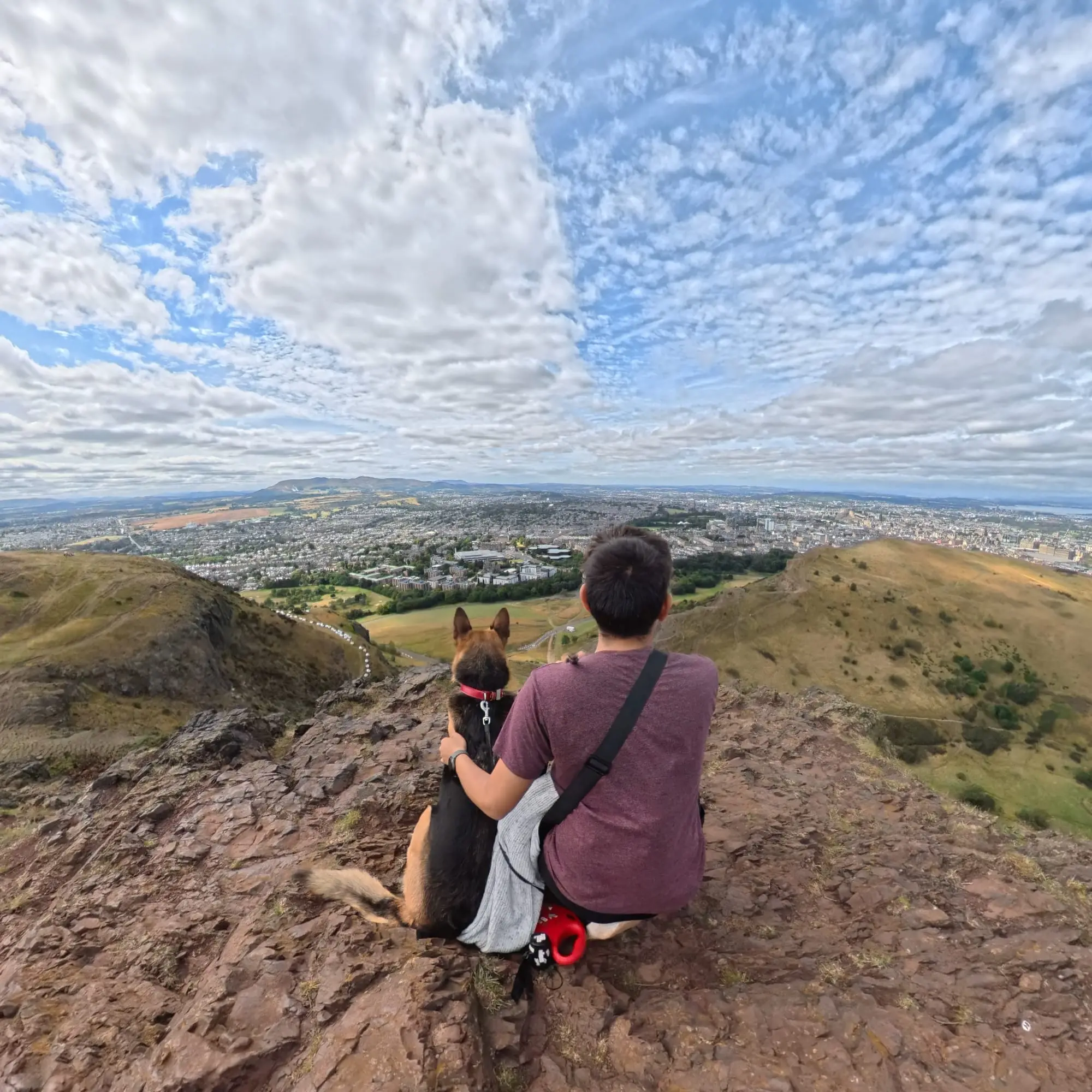 Viaje por Europa de Fernando, Isaac y Lilu durante una pausa en una colina con vista urbana.