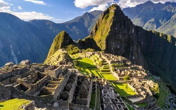 Viaje por Europa y retorno a Cusco simbolizado con una vista de Machu Picchu en los Andes peruanos.