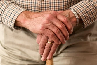 terapia celular Parkinson Japón manos de paciente con temblores sosteniendo bastón