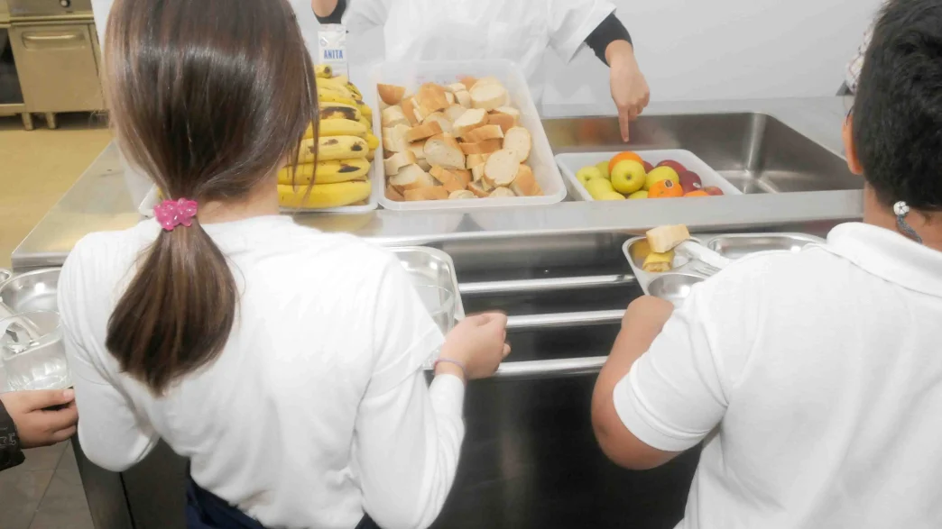 comida escolar saludable con frutas y pan en comedor escolar