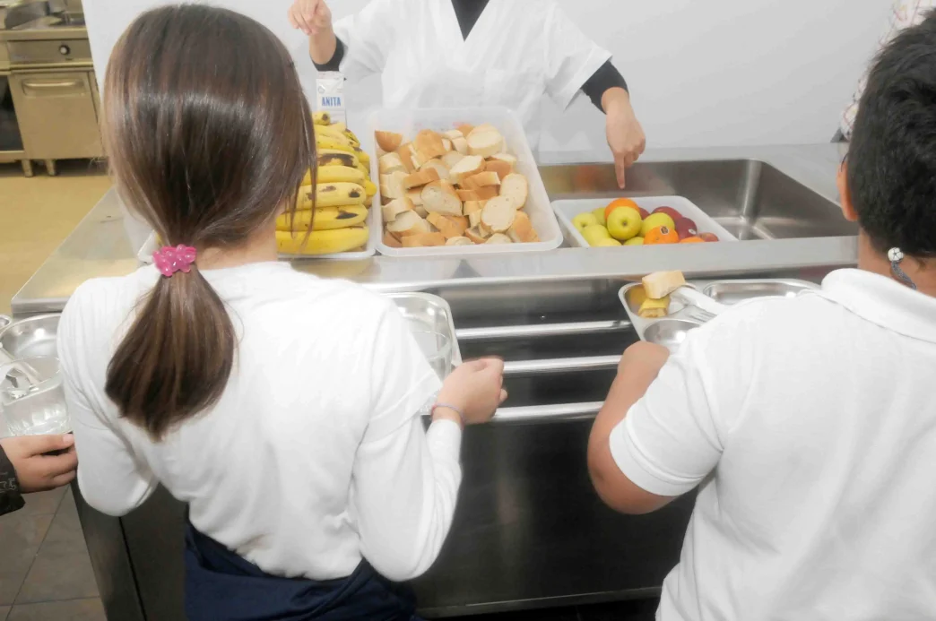 comida escolar saludable con frutas y pan en comedor escolar