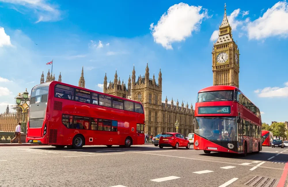 Tarifa Weekend Hopper con autobuses rojos circulando frente al Big Ben en Londres.