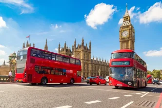 Tarifa Weekend Hopper con autobuses rojos circulando frente al Big Ben en Londres.