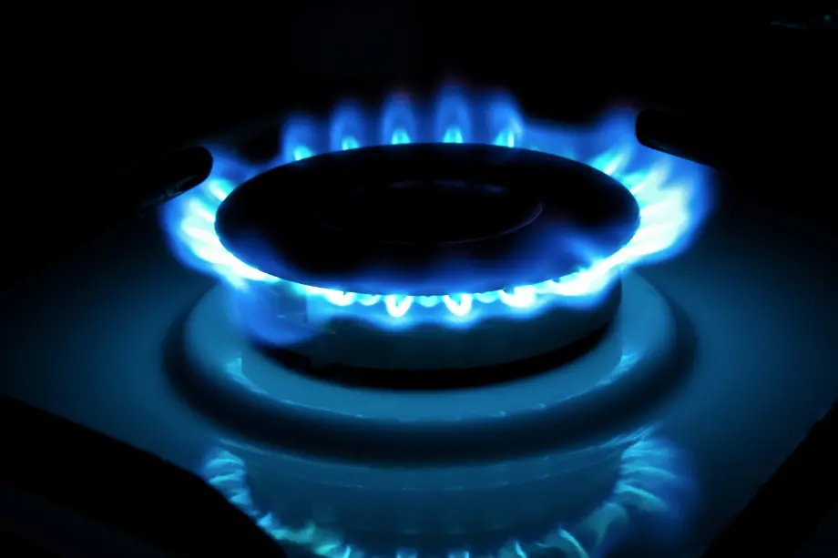 Llama azul de un quemador de gas encendido en una cocina, representando el consumo de energía.