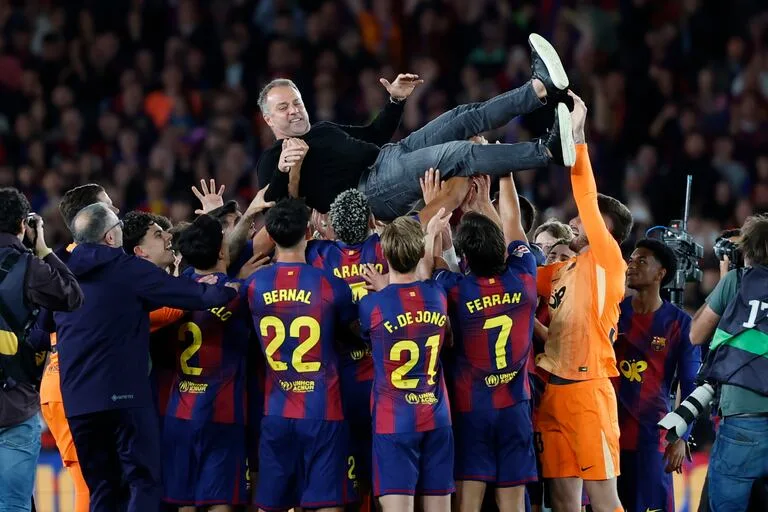 Hansi Flick es levantado por los jugadores del Barcelona campeón 2026 tras ganar LaLiga.