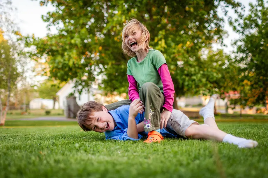 Niños digitales juegan al aire libre mientras expertos recomiendan equilibrar el uso de pantallas con actividad física.