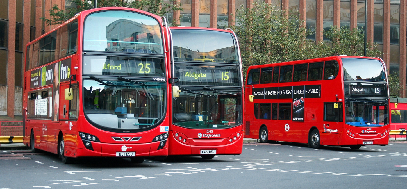 Varios autobuses rojos de dos pisos tradicionales de Londres detenidos en una estación urbana