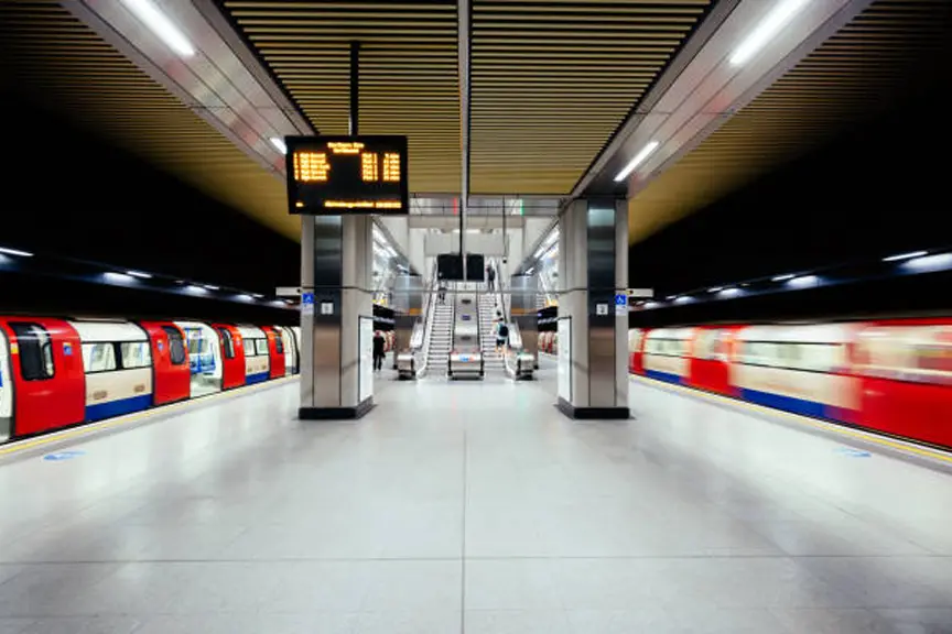 Andén del metro de Londres con trenes en movimiento, ilustrando los cortes en el metro de Londres este fin de semana en las líneas Central, District y Piccadilly