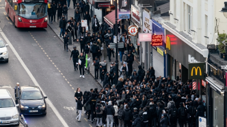 Multitud de adolescentes convocados por un reto viral de TikTok frente a locales comerciales en Clapham, Londres.