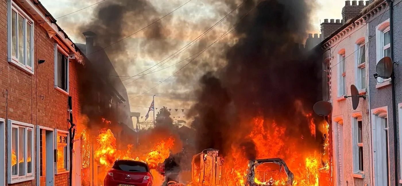 Autobús y vehículos incendiados por manifestantes violentos en una calle de Belfast durante los disturbios.