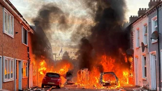 Autobús y vehículos incendiados por manifestantes violentos en una calle de Belfast durante los disturbios.