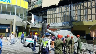Equipos de rescate y militares inspeccionando los escombros de un edificio colapsado tras el terremoto en el sur de Filipinas.