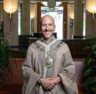 Marcelo Hart-Camus, alcalde chileno del distrito de Waltham Forest en Londres, vistiendo un poncho tradicional durante su ceremonia de posesión.