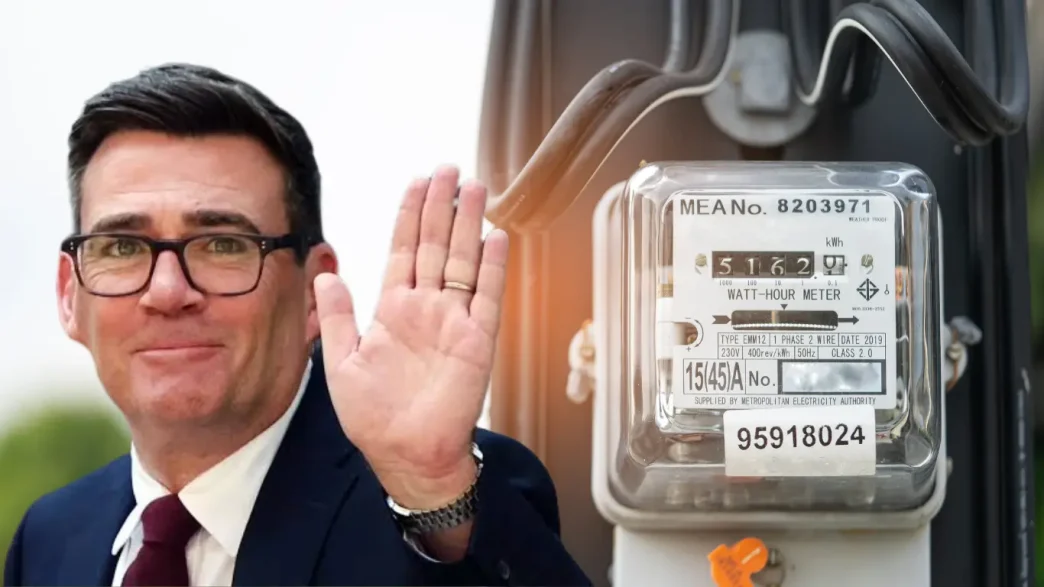 Andy Burnham saludando junto a un medidor de electricidad doméstico.