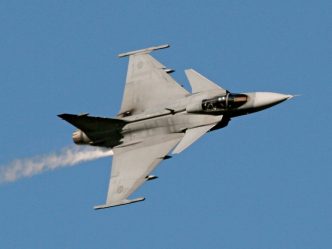 Caza Gripen E de fabricación sueca realizando maniobras en vuelo.