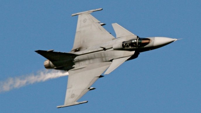 Caza Gripen E de fabricación sueca realizando maniobras en vuelo.