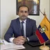 El Cónsul Christian Valencia sentado en su despacho de la Sección Consular de la Embajada del Ecuador en París junto a la bandera del país.