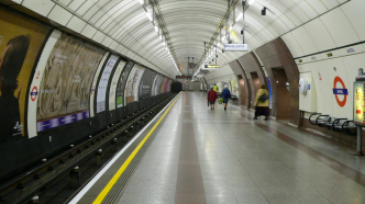 Pasajeros consultando un mapa de rutas en el metro de Londres.